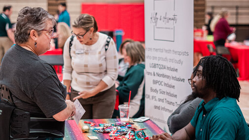 Employee speaking with a vendor at their booth at the wellness fair
