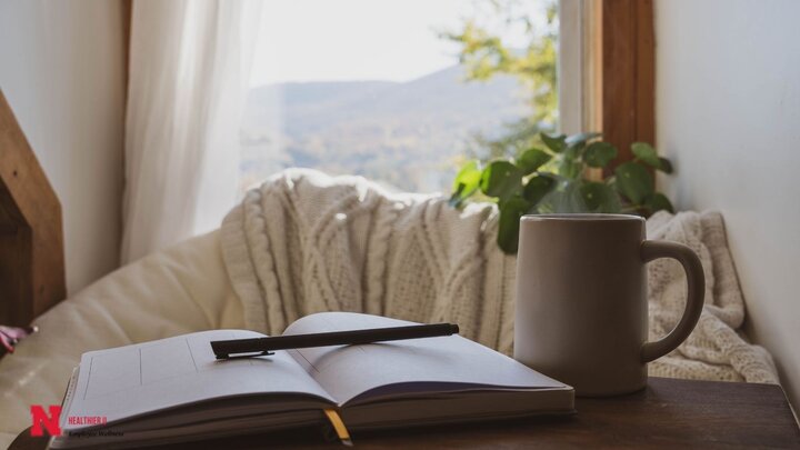 Open Notebook with a pen and a white coffee mug