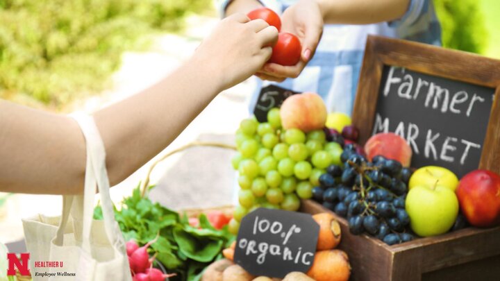 person at fruit stand grabbing food from vendor's hand