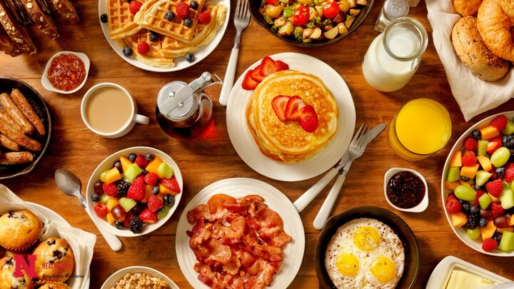 Various assortment of breakfast food including pancakes, fruit, bacon, and waffles