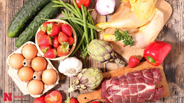 Group of food items including eggs, strawberries, artichokes, peppers, cucumbers, and red meat.