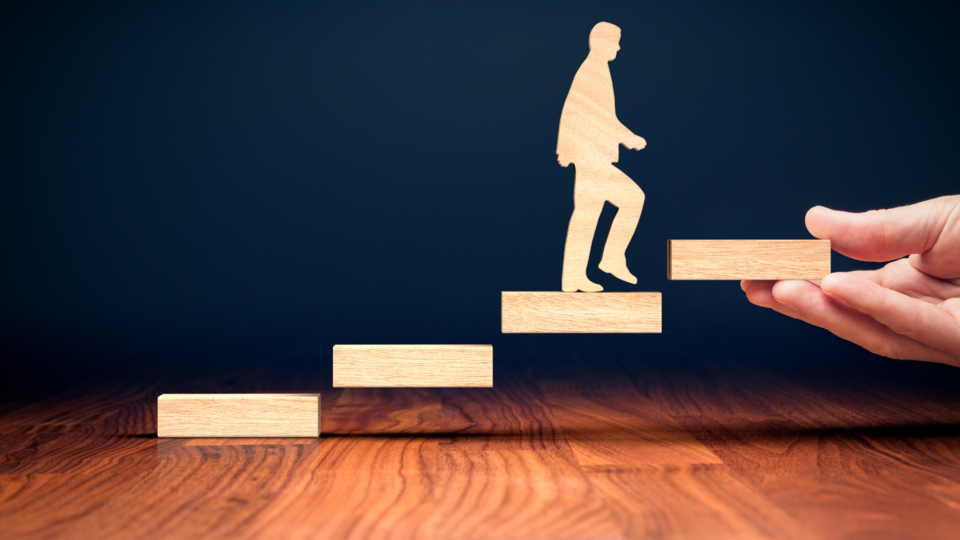 Wooden person walking up blocks