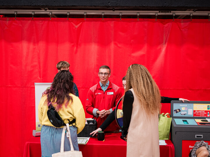 Professional speaking with two employees at booth