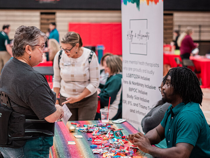 Employee speaking with a vendor at their booth at the wellness fair